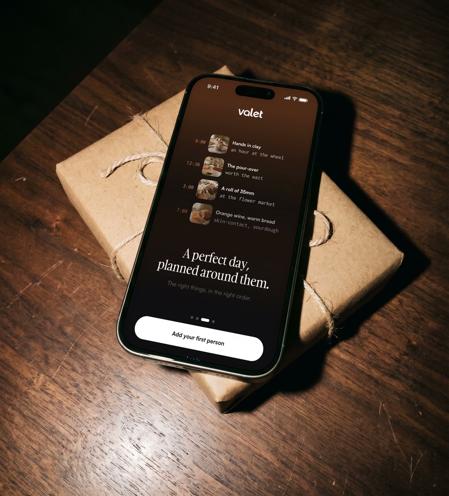 Valet on a phone lying on a wrapped gift, stepping through who someone is and the day it planned for them